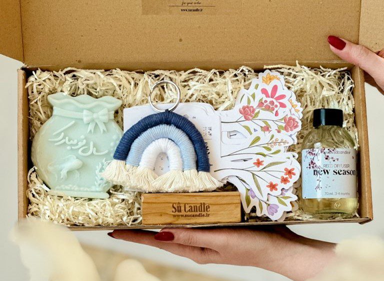 پک بهاره ۱۴۰۴ این پک شامل: شمع " سال نو مبارک " مدل تنگ ماهی ساخته شده از موم گیاهی سویا و رایحه " گلها " خوشبوکننده خانگی با رایحه فوق العادهء " فصل جدید " جا کلیدی طرح رنگین کمان تقویم ۱۴۰۴ با پایه چوبی تمام این آیتمها، داخل جعبه قرار میگیرد و با همین بسته بندی به دست شما خواهد رسید. متن روی جعبه: دعای تحویل سال پارسی این پک برای عیدی به همکاران، کارمندان و عزیزانتون بسیار مناسبه. امسال، متفاوت عیدی بدید. پک بهاره ۱۴۰۴